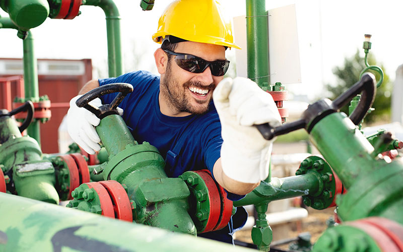 Smiling Man at Work Wearing Safety Glasses, Gloves, and Hard Hat Smiling Man at Work Wearing Safety Glasses, Gloves, and Hard Hat