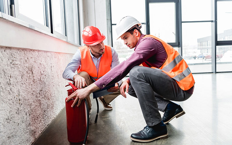 Two Men Working with Hard Hats and Safety Vests Two Men Working with Hard Hats and Safety Vests